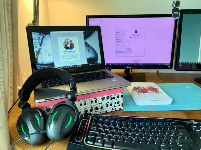 Computer workstation with audio headphones ready for virtual meeting