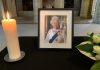 Queen Elizabeth II photo withlarge candle and flower in church