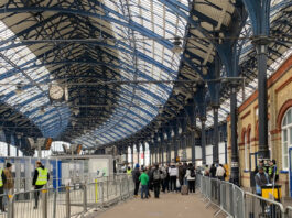 Transport staff cordon off football supporters arriving at Brighton rail station in Sussex