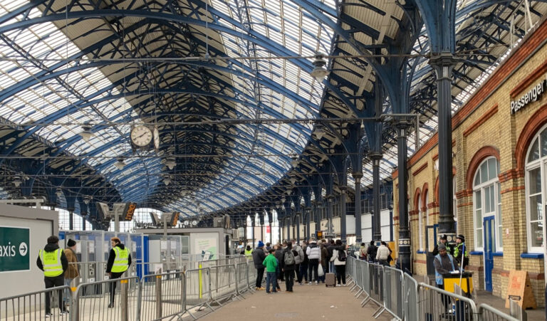 Transport staff cordon off football supporters arriving at Brighton rail station in Sussex