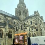 Big screen displays King Charles III in coronation coach, outside Chichester cathedral in West Sussex